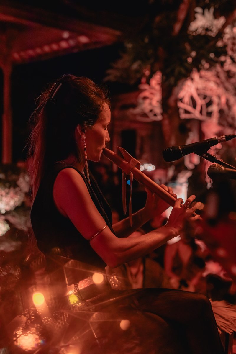 Pao Pamaki playing a Native American flute live under red light