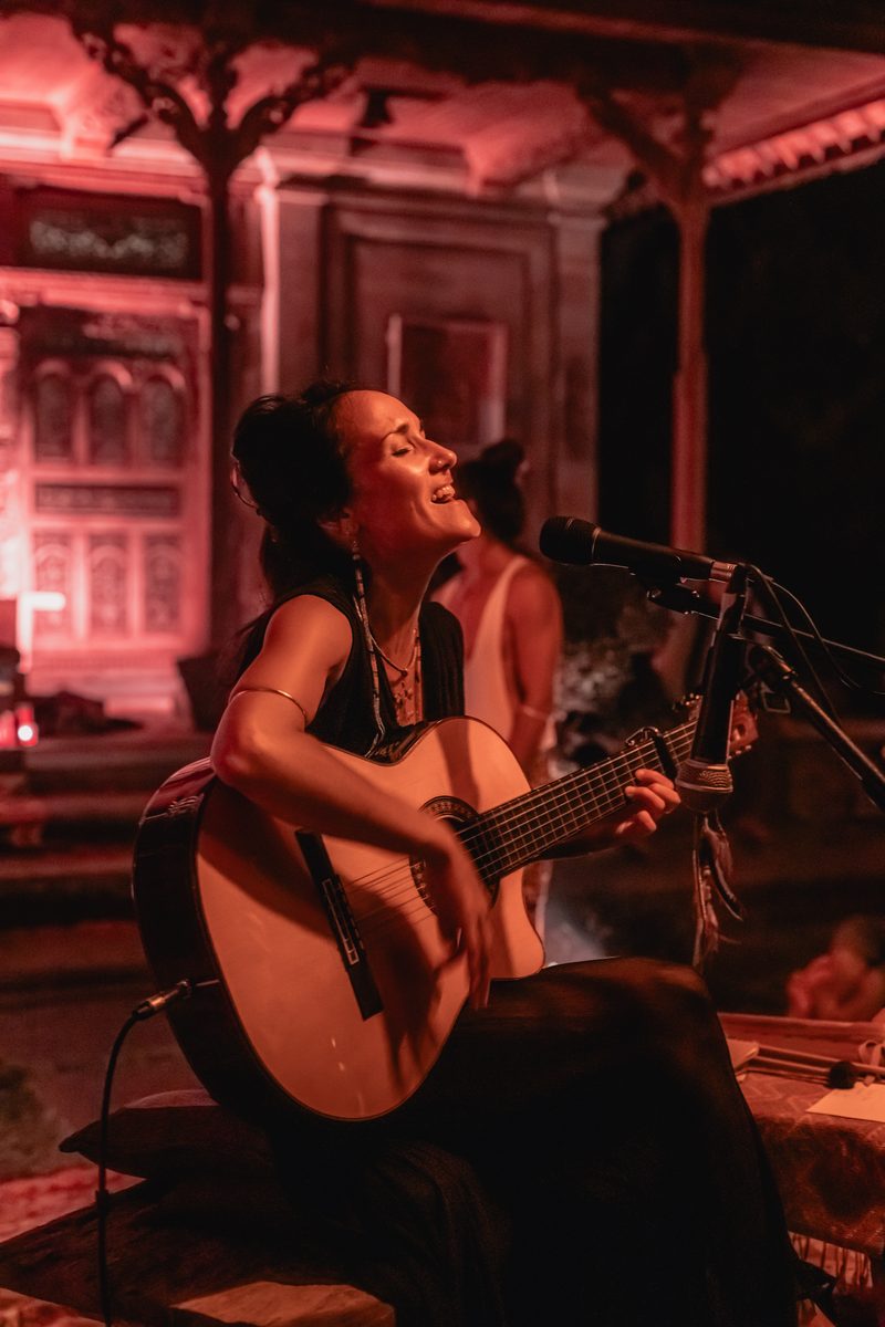 Pao Pamaki singing live with guitar under red light