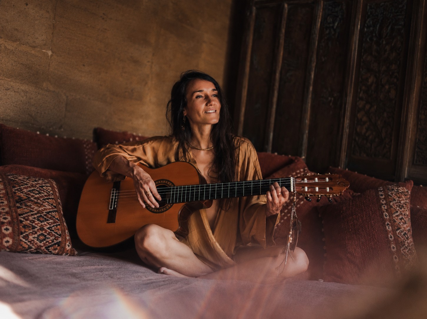 Pao Pamaki playing guitar, candid and smiling